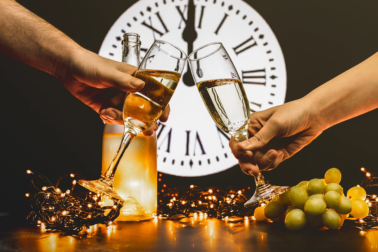Anstossen mit Sekt und Trauben um Mitternacht an Silvester